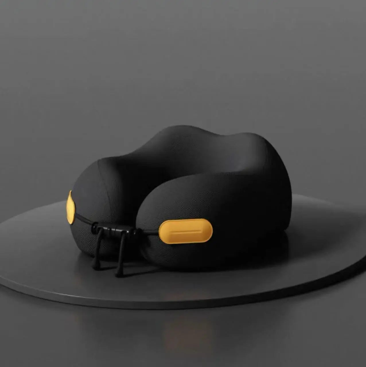 Black ergonomic travel neck pillow with yellow accents displayed on a gray platform, Elarose