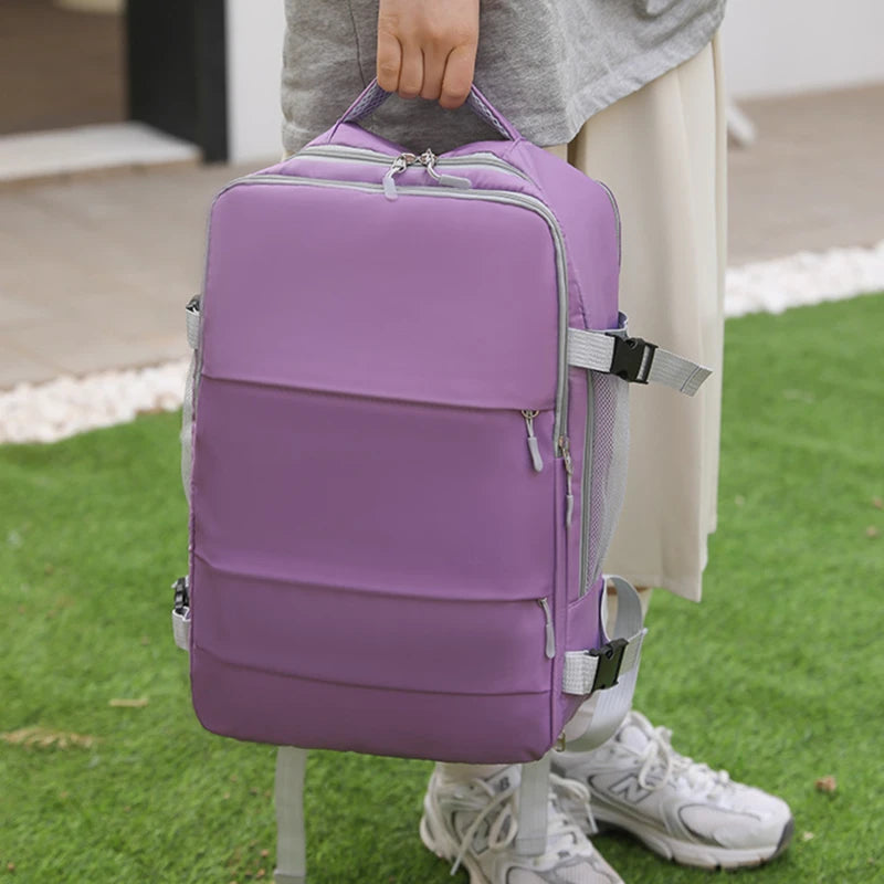 Person holding a large purple backpack outdoors on green grass, Elarose lifestyle accessory