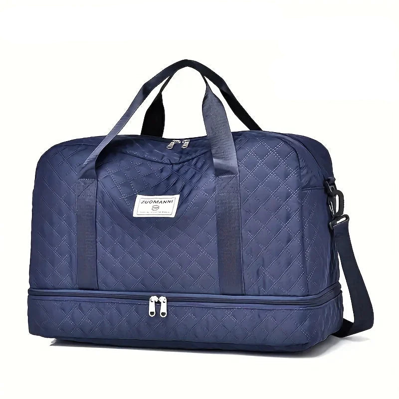 Navy blue quilted travel duffel bag with dual handles, shoulder strap, and bottom zipper compartment