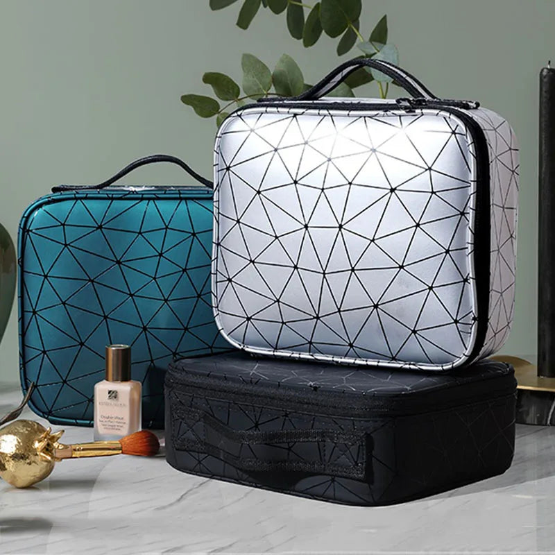 Geometric pattern Elarose makeup bags in silver, teal, and black on marble surface