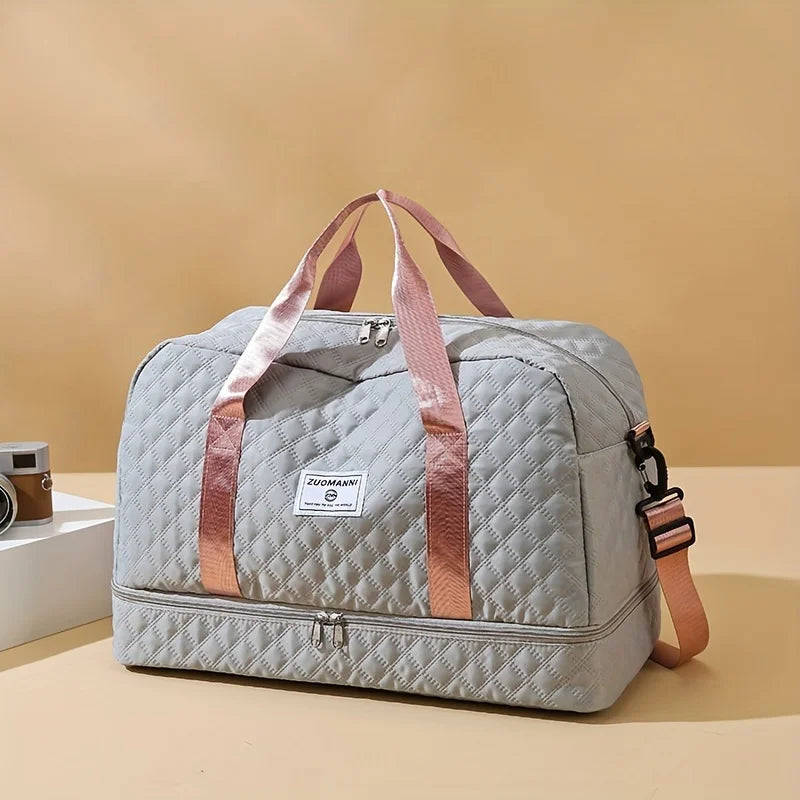 Quilted gray duffel bag with pink handles on beige background, Elarose travel accessory