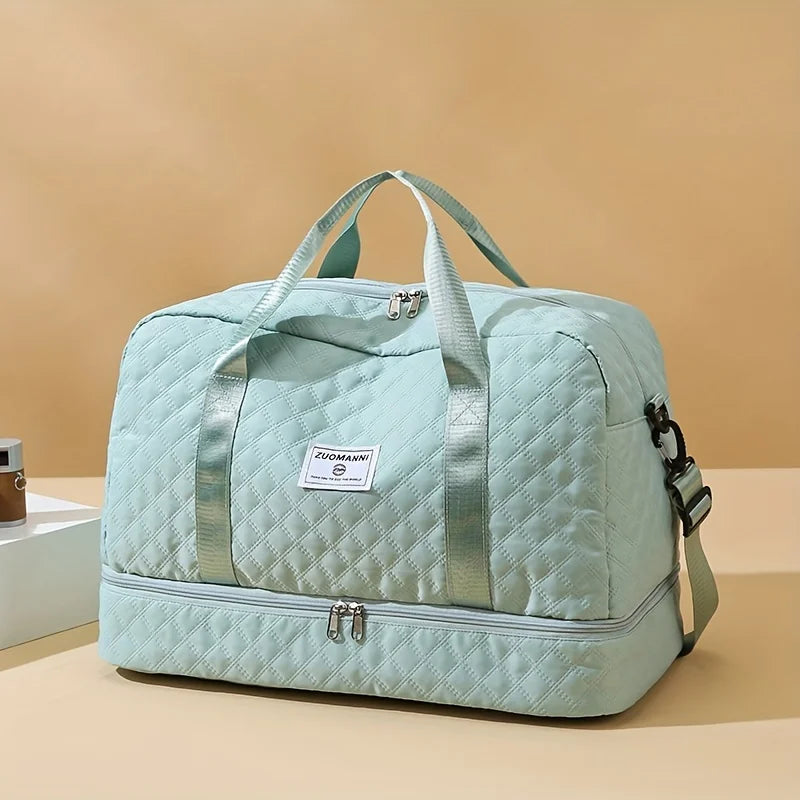 Light blue quilted travel duffel bag with handles, zipper pockets, and detachable strap
