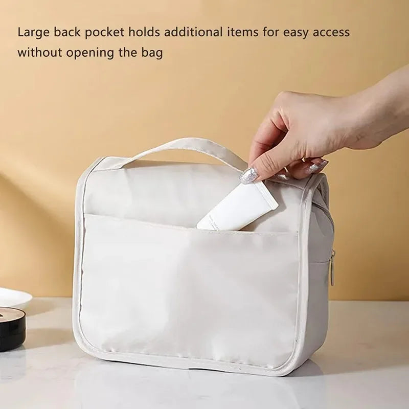 Elarose beige cosmetic bag with large back pocket, hand placing tube inside, organized storage