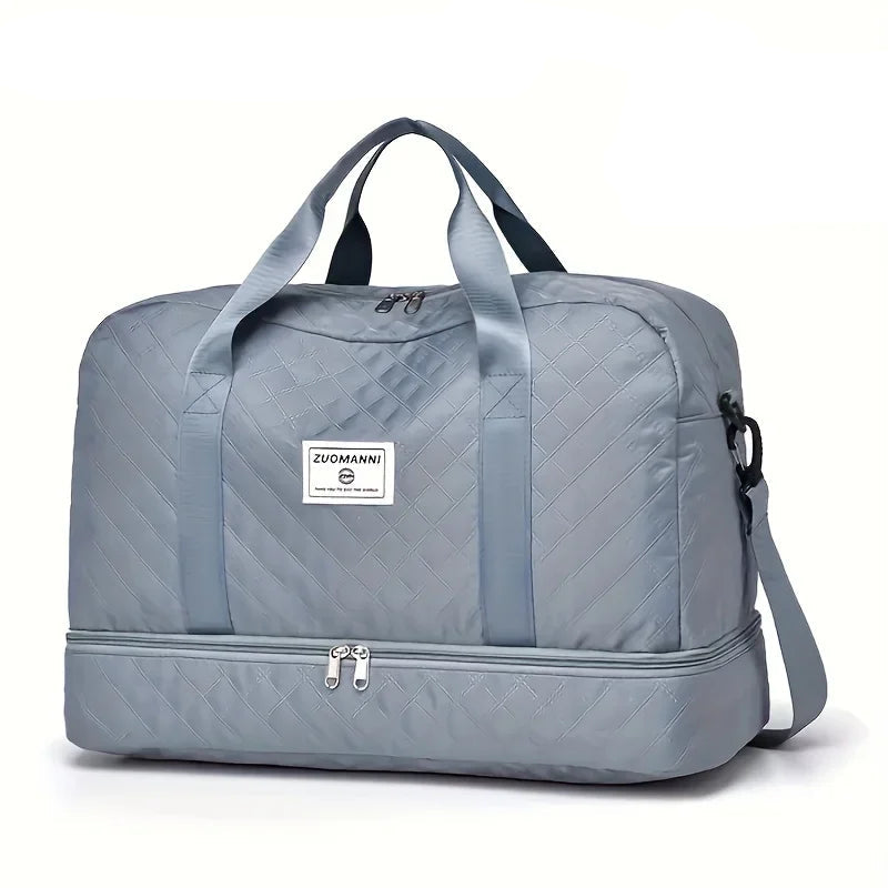 Light gray quilted travel duffel bag with handles, shoulder strap, and front zipper pocket