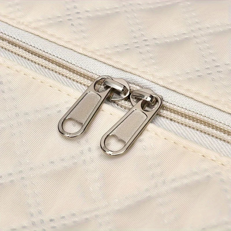 Close-up of beige fabric with double silver zippers, Elarose bag detail