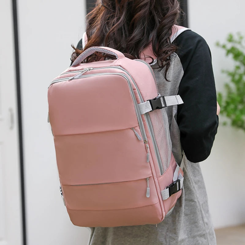 Woman wearing a large pink Elarose backpack with multiple zippers and gray straps outdoors
