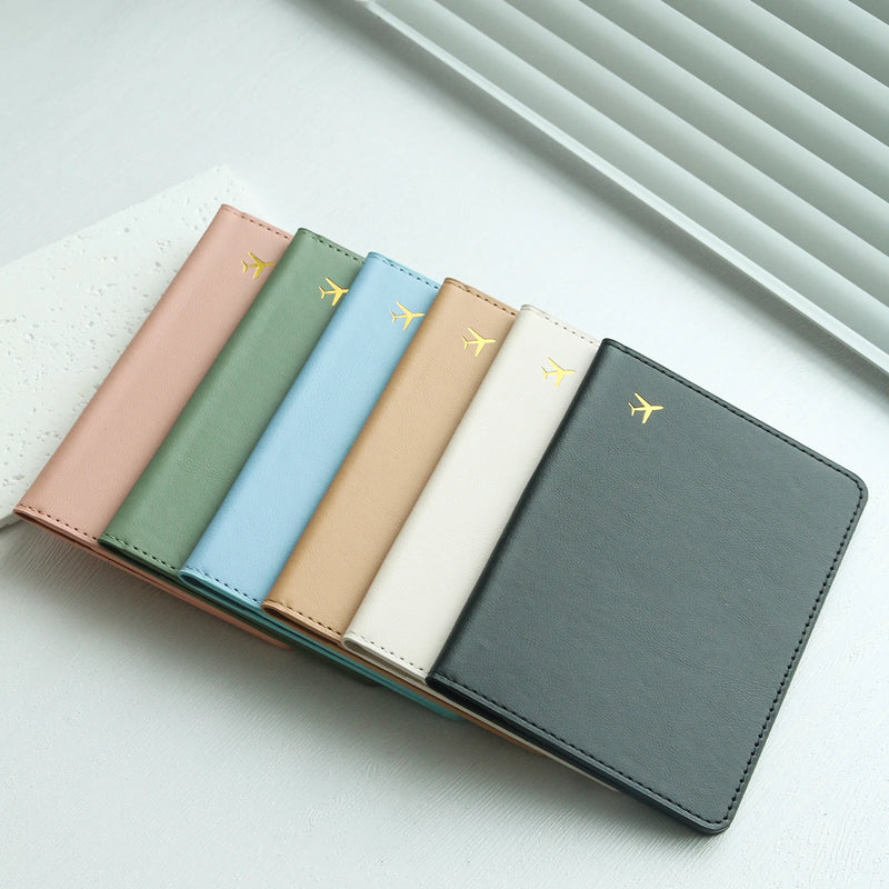 Elarose pastel travel passport holders arranged on a white desk near window blinds